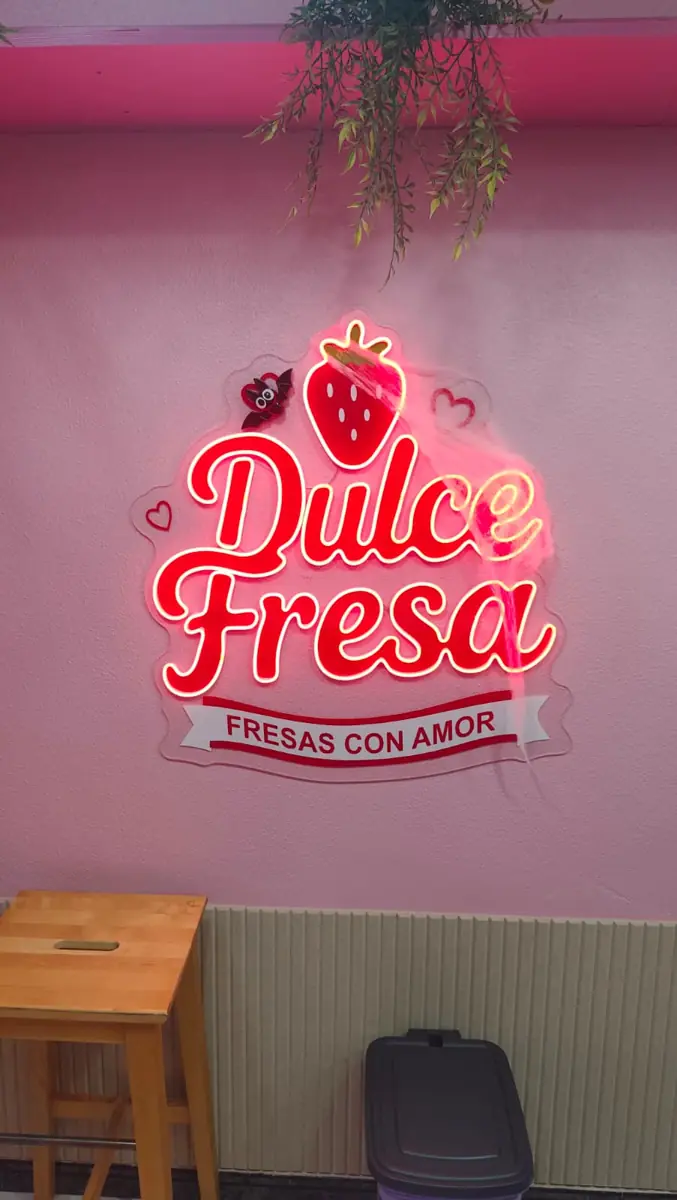 El cartel de neón de Dulce Fresa en la pared rosa